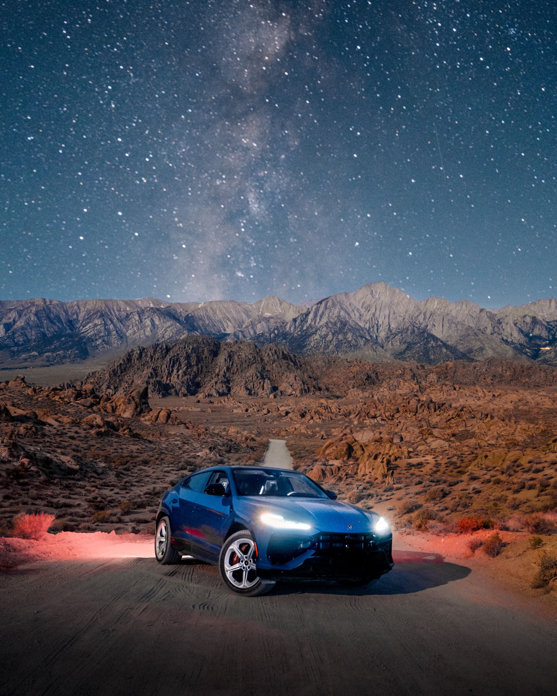 Blue Lamborghini Urus under the Milky Way in a desert at night